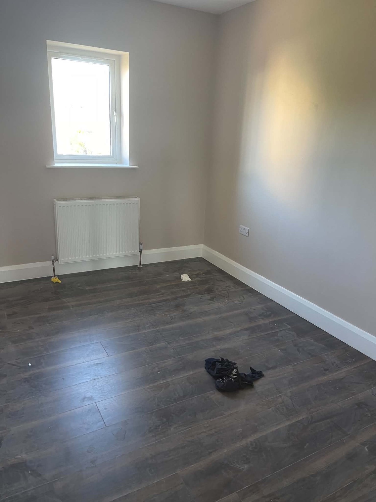 Empty bedroom before cleaning with debris and dusty marks across the floor
