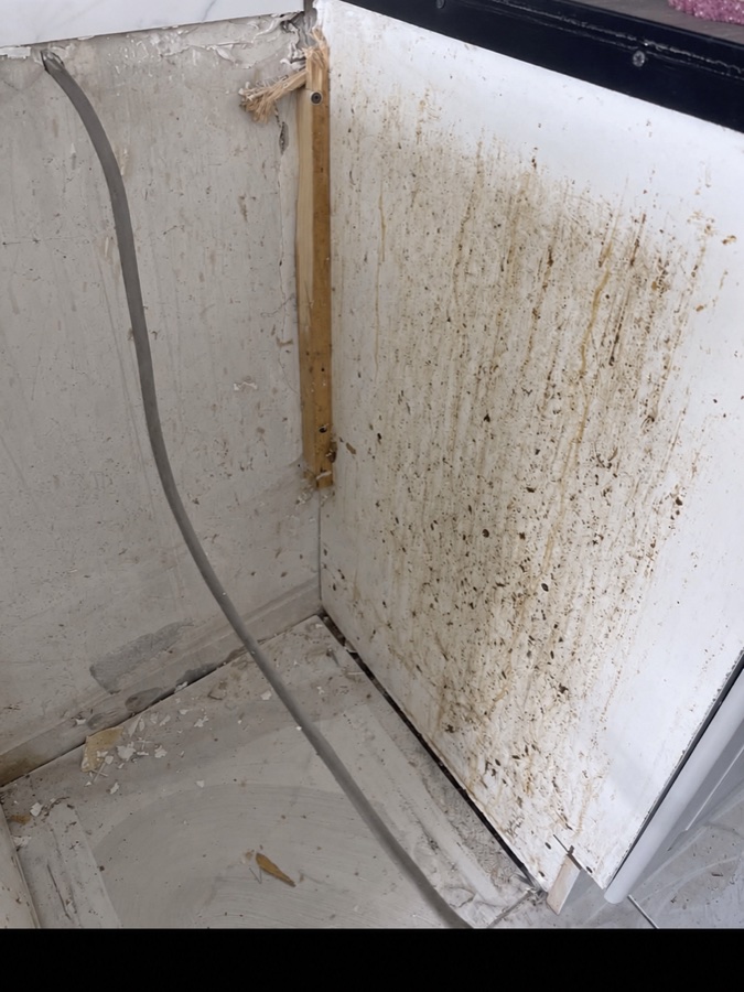 Side of a cooker before cleaning, showing heavy dirt and residue