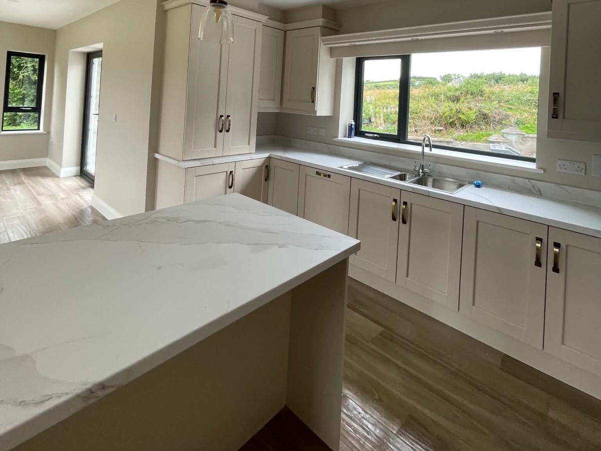Bright fitted kitchen after cleaning, with polished floor, clear worktops and clean sink area