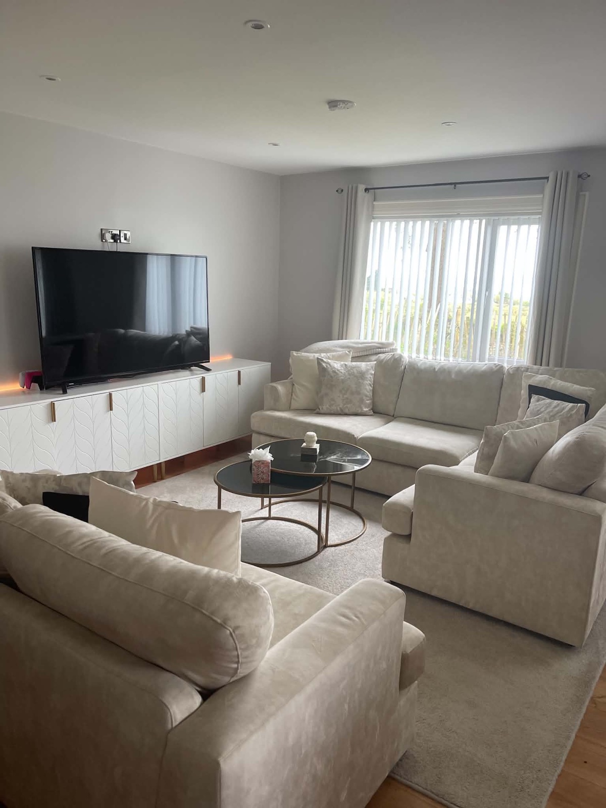 The same living room after cleaning and resetting, with clear tables and neatly arranged seating